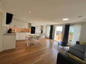 a kitchen and living room with a table and a couch at Modern nyproduktion nära ALV in Vimmerby