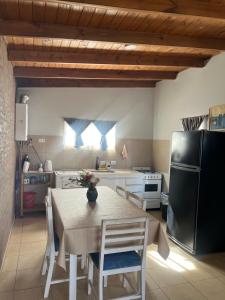 a kitchen with a table and a black refrigerator at Casita en plottier in Plottier