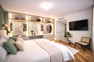 a bedroom with a large white bed and a flat screen tv at Sorrento Downtown in Sorrento