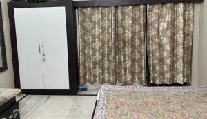 a bedroom with a bed and a window with curtains at Dj's home stay in Jodhpur