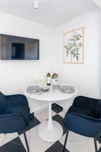 a white table with two chairs and a bottle of wine at Aplo Chios Deluxe Apartments in Chios