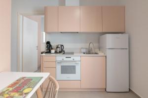 a kitchen with a white refrigerator and a table at Aplo Chios Deluxe Apartments in Chios