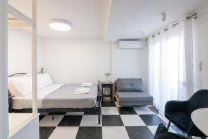 a bedroom with a bed and a chair at Aplo Chios Deluxe Apartments in Chios