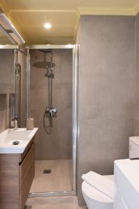 a bathroom with a shower and a toilet and a sink at Aplo Chios Deluxe Apartments in Chios +113 photos