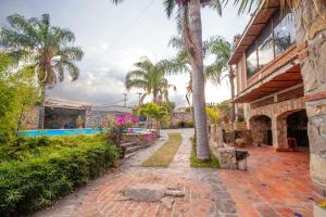 a house with a palm tree and a swimming pool at Rancho alegre in Jocotepec