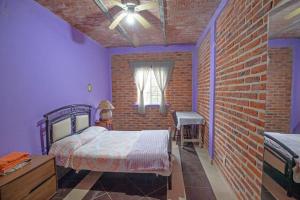 a bedroom with a bed and a brick wall at Rancho alegre in Jocotepec