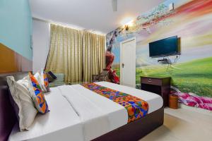 a bedroom with a large bed with a painting on the wall at DG Hotel Green Vista in Jaipur