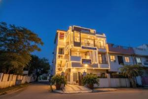 a tall white building with trees in front of it at DG Hotel Green Vista in Jaipur