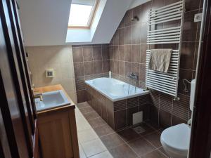 a bathroom with a tub and a toilet and a sink at Fay-home in Odorheiu Secuiesc +24 photos