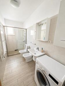 a bathroom with two toilets and a washing machine in it at Apartments Renato Mužić Cres in Cres +30 photos