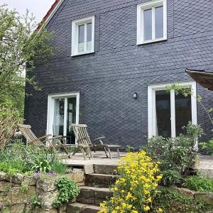 a black house with two chairs on a porch at Hahnhaus in Burscheid