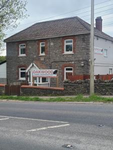 a brick building with a sign in front of it at Oakwood Airport Accommodation in Lulsgate Bottom