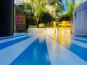 a blue swimming pool with a table and yellow chairs at Hot Jacuzzi & Ice Bath Apartment in Ika