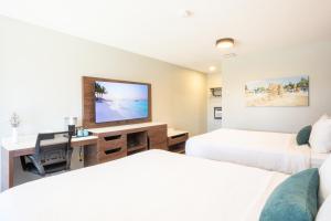 a hotel room with two beds and a desk with a television at The Tide's Out in Parksville +13 photos