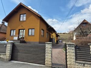 a yellow house with a brick fence in front of it at Fay-home in Odorheiu Secuiesc