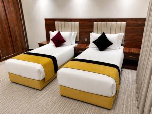 two beds in a hotel room with at ساتورن هاوس للشقق الفندقية in Tabuk
