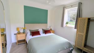 a bedroom with a large bed and a window at Yr Hen Stabl - The Old Stable in Llangerniew