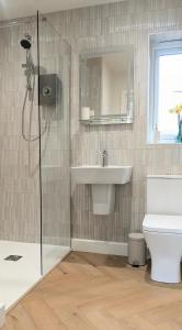 a bathroom with a shower and a sink and a toilet at Yr Hen Stabl - The Old Stable in Llangerniew +31 photos