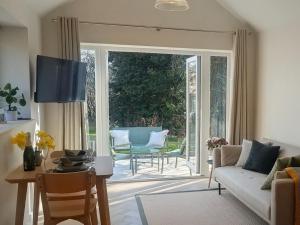 a living room with a couch and a table at Yr Hen Stabl - The Old Stable in Llangerniew