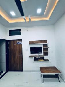 a room with a table and a tv on a wall at Shree Vishwakarma place in Khātu +19 photos