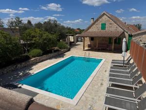 a swimming pool in the backyard of a house at Rural house Mudrinic "Ivini dvori" in Bogatić