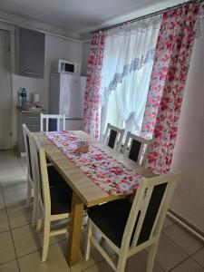 a kitchen with a wooden table with chairs and a dining room at Apartament Wiejska Sielanka in Ryn