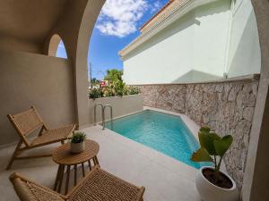 a swimming pool on a patio with chairs and a table at ABATON Luxury Resort in Tsilivi