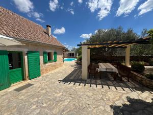 a patio of a house with a table and a bench at Rural house Mudrinic "Ivini dvori" in Bogatić