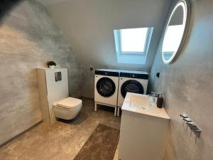 a bathroom with a washing machine and a toilet at Modern nyproduktion nära ALV in Vimmerby