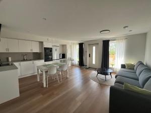 a living room with a blue couch and a kitchen at Modern nyproduktion nära ALV in Vimmerby +18 photos