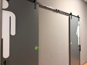 a sliding door with green arrows on a wall at Albergue Argemira - Grupo Arcanos in Caldas de Reis +17 photos