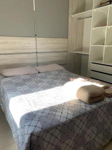 a bedroom with a bed with a blanket and shelves at Hotel Airton in Ivaiporã