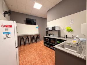 a kitchen with a sink and a counter with stools at Albergue Argemira - Grupo Arcanos in Caldas de Reis