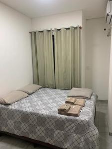 a bedroom with a bed with two wooden blocks on it at Hotel Airton in Ivaiporã