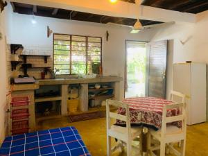 a kitchen with a table and chairs and a refrigerator at Villa Milu in Jambiani