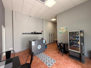 an empty room with a refrigerator and tables and chairs at Albergue Argemira - Grupo Arcanos in Caldas de Reis