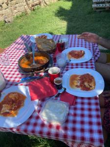 a picnic table with plates of food on it at Farm River and Kanoe in Poliçan +37 photos