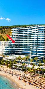 a red frisbee flying over a beach with a large building at Eddy's Luxury Suites - Ilyonis in Shëngjin