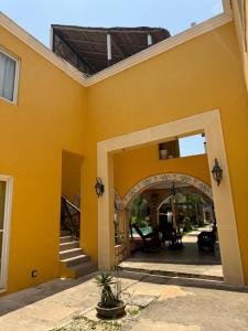 an entry to a yellow building with an archway at HotelJosefadeMaria in Izamal