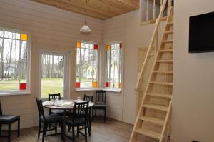 a dining room with a table and chairs and windows at Retro Ķemeri in Jūrmala