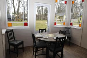 a dining room with a table and chairs and windows at Retro Ķemeri in Jūrmala