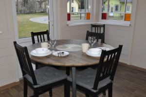 a wooden table with chairs and plates and wine glasses at Retro Ķemeri in Jūrmala +6 photos