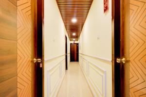 a hallway with white walls and a wooden ceiling at Hotel O Hotel R Pacific in Hyderabad