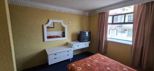 a bedroom with a mirror and a bed and a television at Hotel San Jeronimo Inn in Toluca