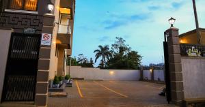 a parking lot outside of a building at night at Travellers Palace Hotel in Kampala