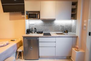 a small kitchen with a sink and a microwave at Mediterranean Studio Halkidiki in Nea Kallikrateia