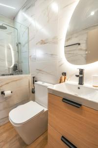 a bathroom with a toilet and a sink and a mirror at Mediterranean Studio Halkidiki in Nea Kallikrateia