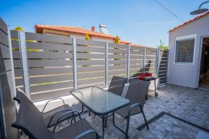 a patio with a table and chairs and a fence at Mediterranean Studio Halkidiki in Nea Kallikrateia +3 photos