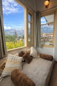 a couch in a room with a large window at Sixtofifty Stays in Dharmsāla