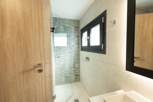 a bathroom with a shower and a sink at Cynthia in Nea Vrasna +84 photos